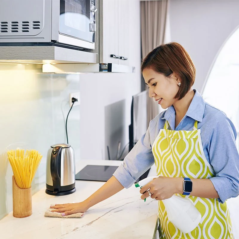 A person wiping a kitchen worktop